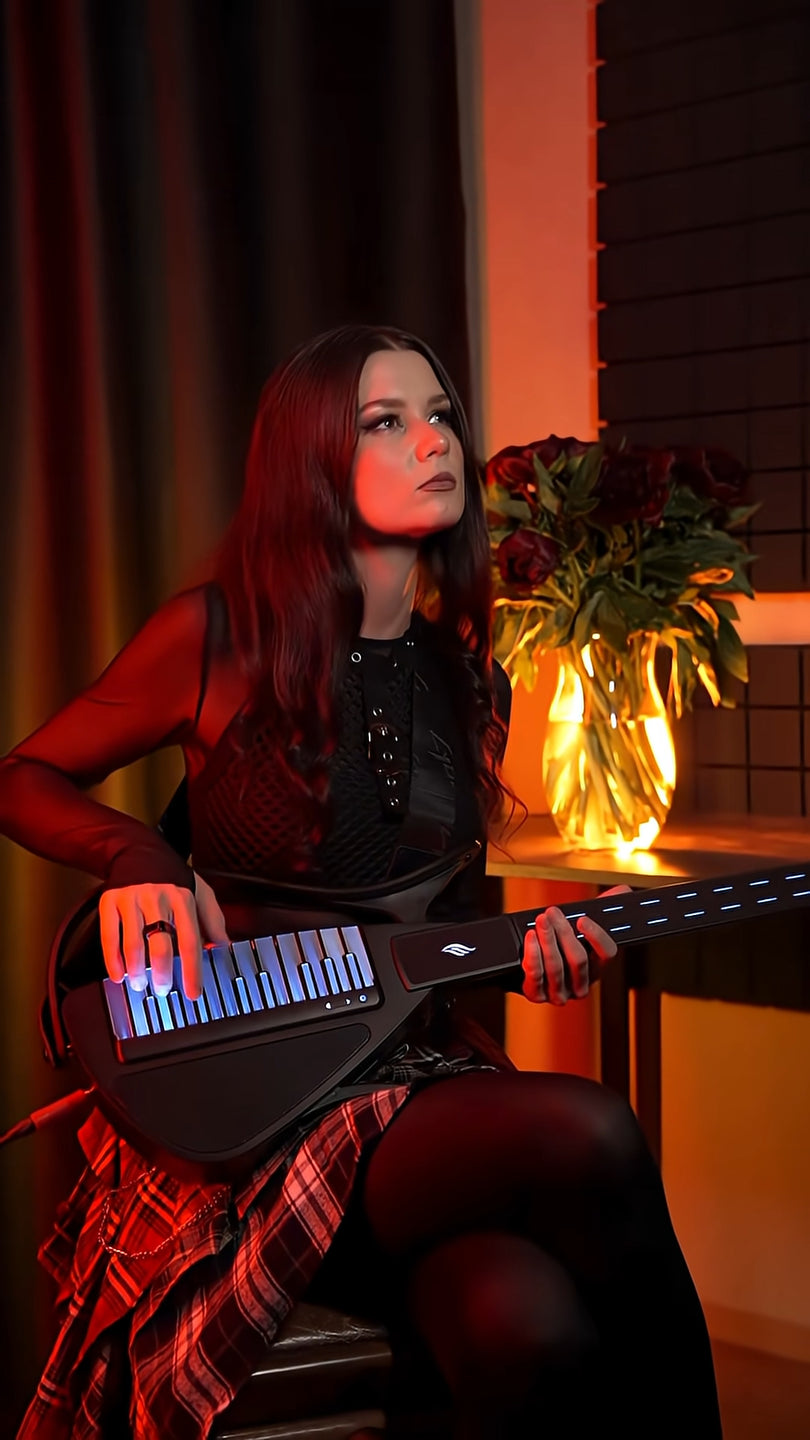 Person playing a Cyber-G guitar with a warm, indoor setting