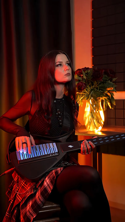 Person playing a Cyber-G guitar with a warm, indoor setting