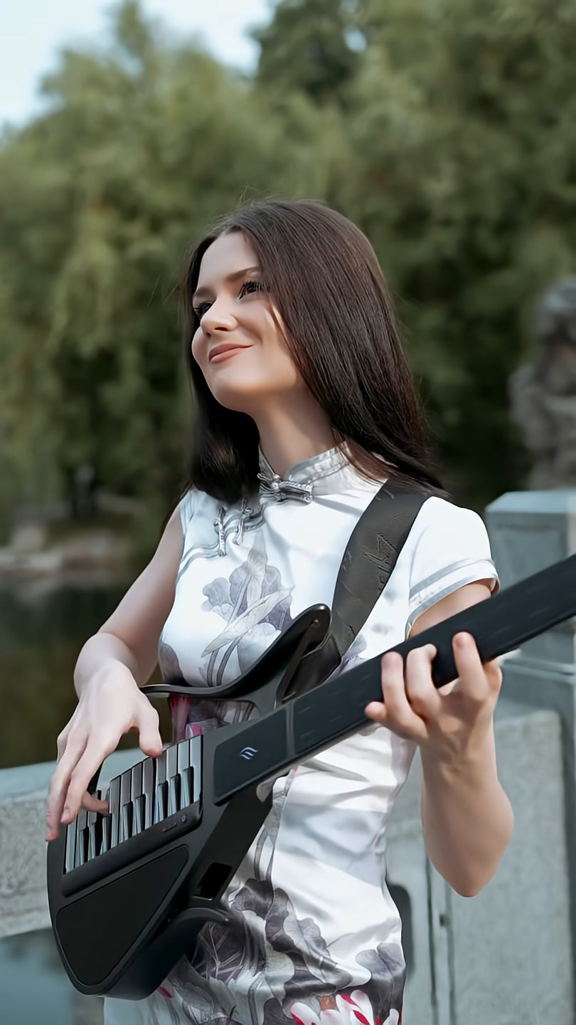 Woman holding a Cyber-G guitar outdoors with greenery in the background