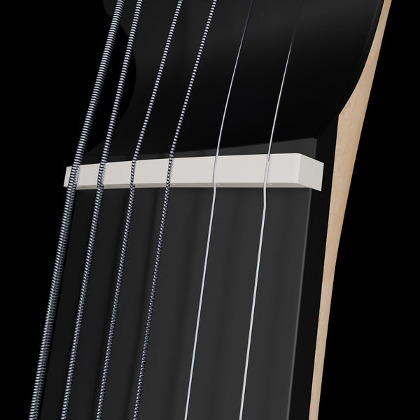 Close-up of a guitar's bone nut and strings on a black background